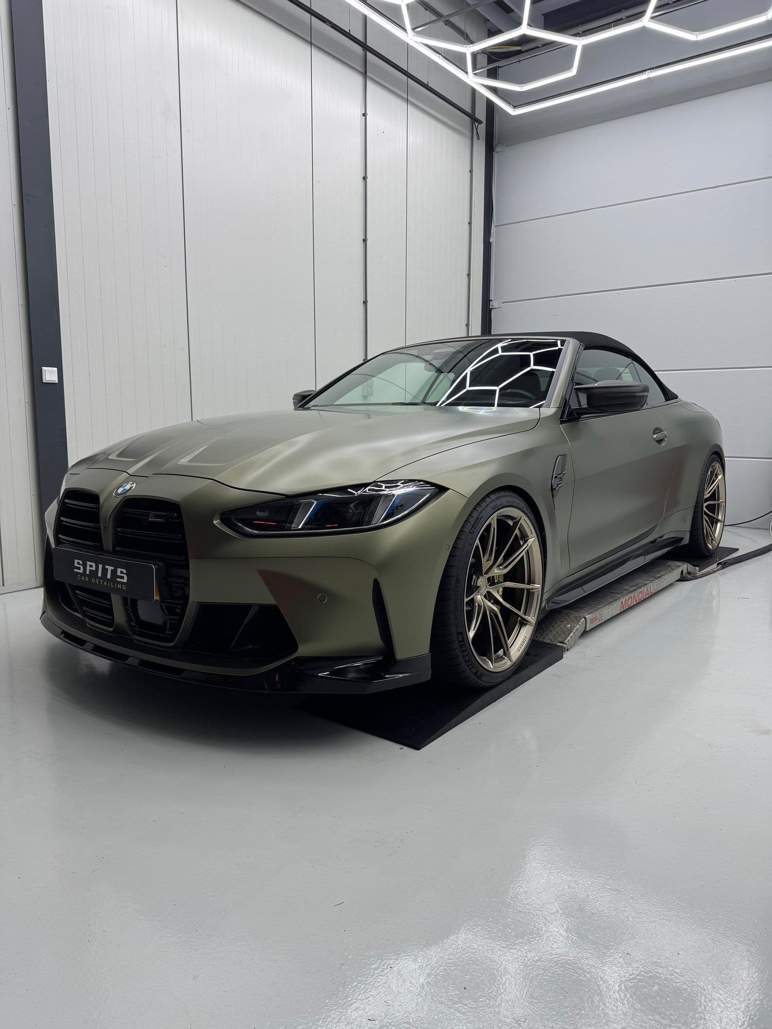 Matte olijfgroene BMW M4 Competition Cabrio in de studio van Spits Car Detailing
